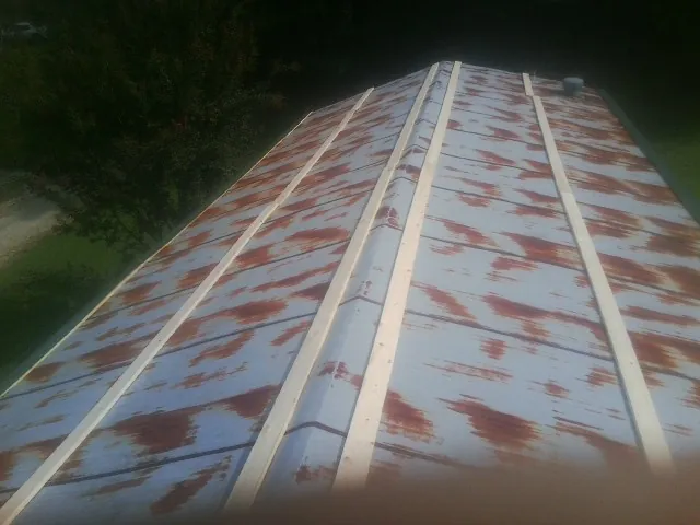 Rusted metal roof panels with new wood purlins before replacement — Storm Damage Roof Repair in Mc Grann by Roofing Brothers