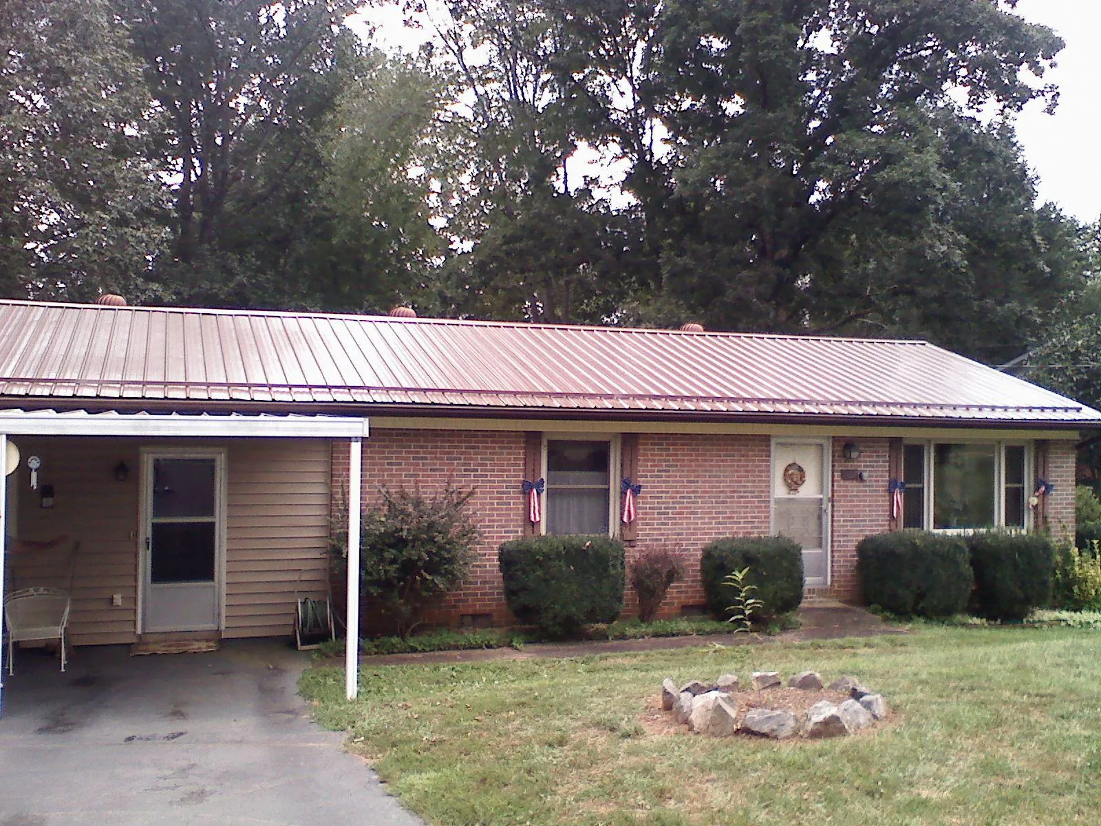 Bronze metal roof and carport on a brick ranch home — Roof Repair work by our crew in Mc Grann
